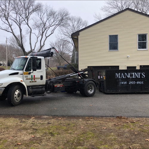 Mancini’s demolition truck parked in front of residential home in Rhode Island – family-owned demolition company